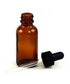 Amber Glass Bottle with Dropper - 1oz with its pipette lying beside it on a white background, exuding a witchy aesthetic.
