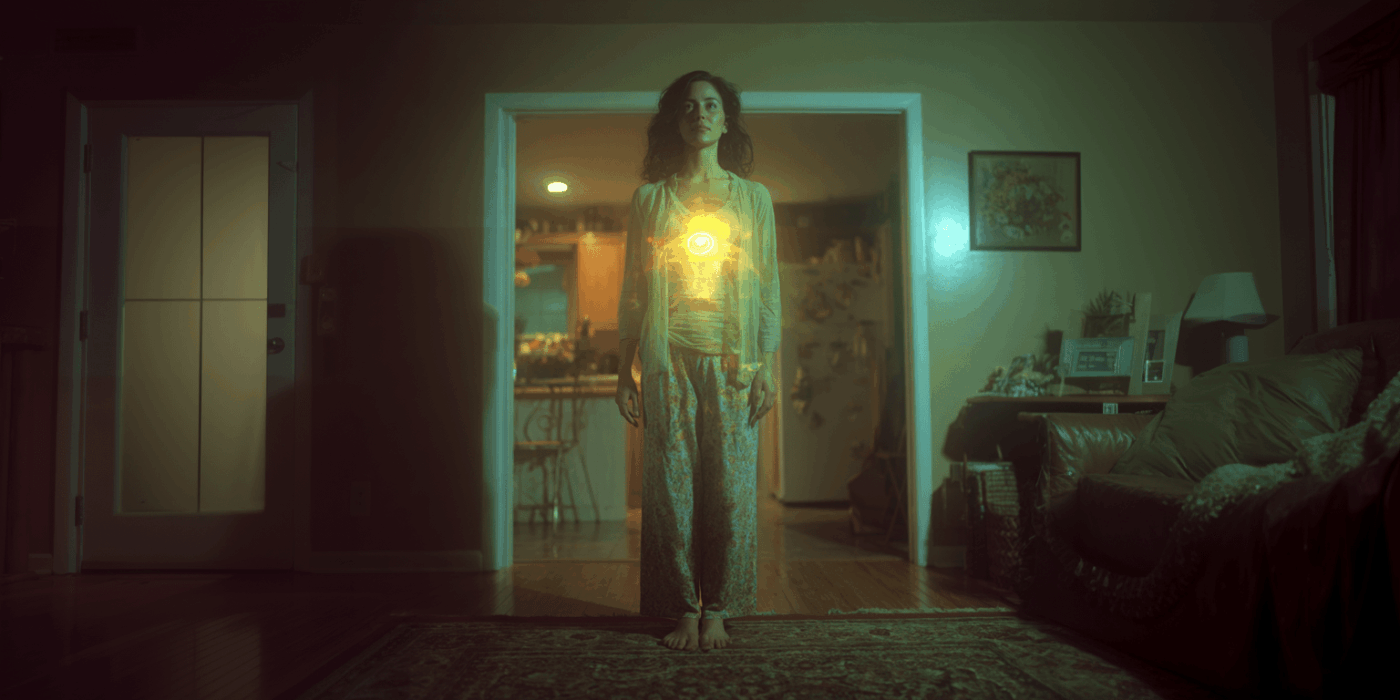 a woman standing in a room with a glowing light during her jupiter protection spell