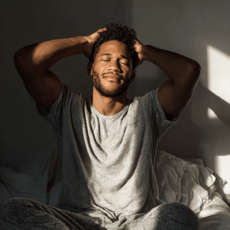 5 Easy Ways to Practice Daily Reiki for Healing & Balance 2 a man sitting on a bed with his eyes closed doing his daily reiki practice in the morning
