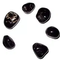 Tourmaline vs. Onyx: The Key Differences Between These Protective Crystals 3 Polished black stones arranged in circle. This is black onyx. black tourmaline vs. black onyx