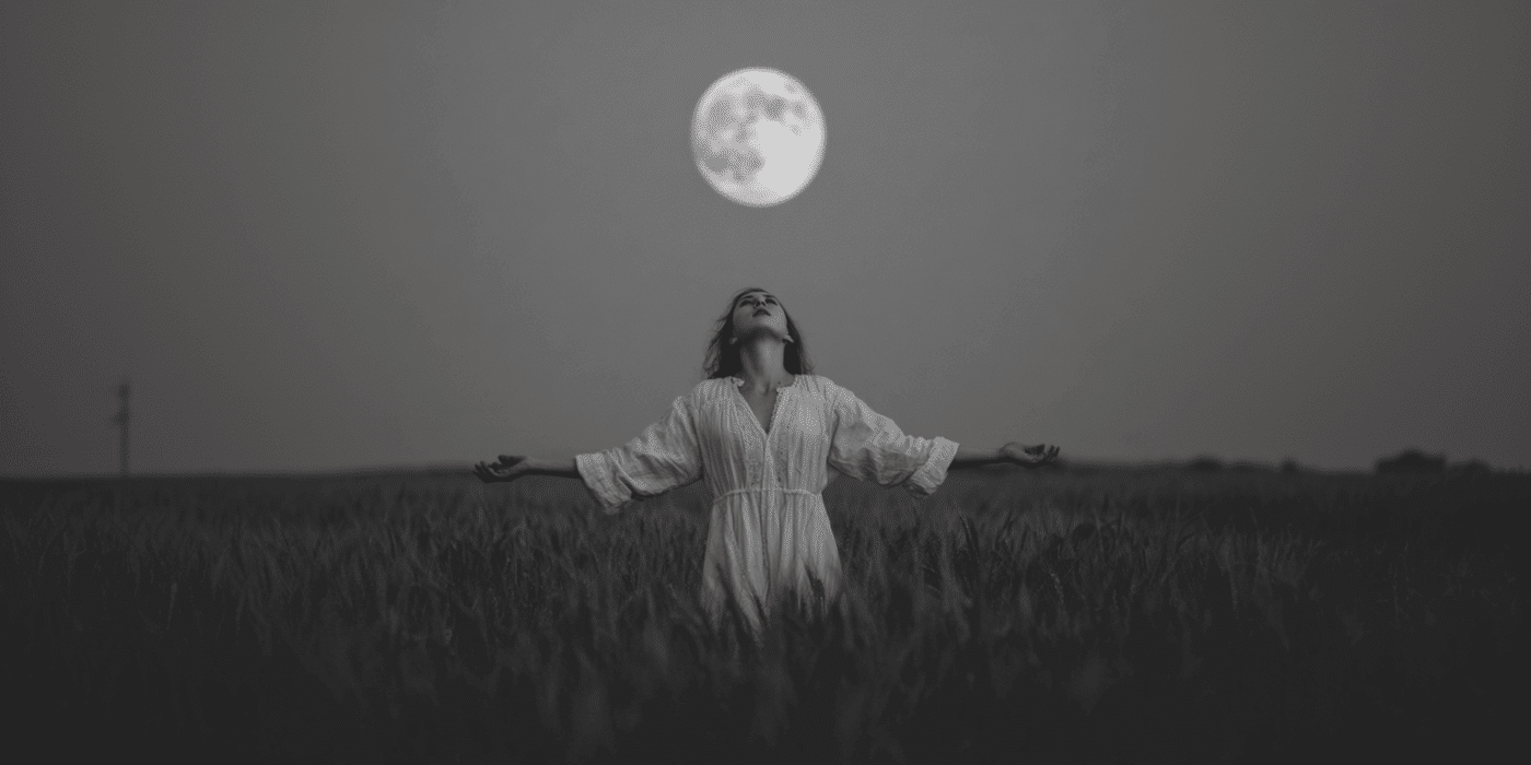 Full Moon Chant For 5 Sacred Gifts 1 A woman standing under a full moon with her arms outstretched as she does a full moon chant