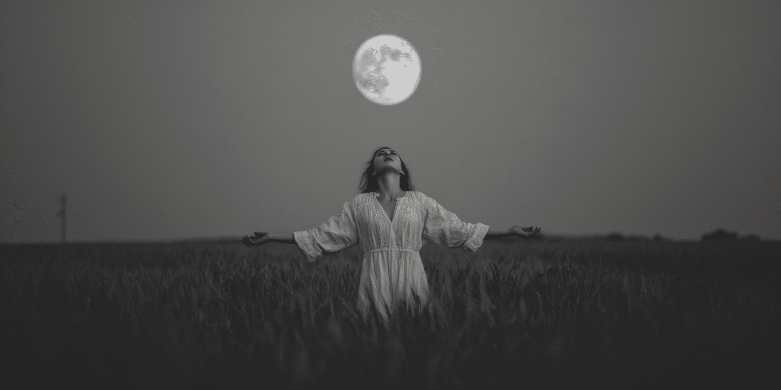A woman standing under a full moon with her arms outstretched as she does a full moon chant