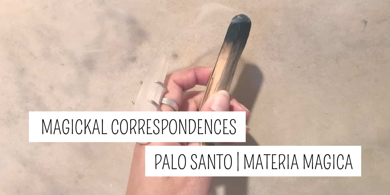 A hand holding a piece of palo santo wood over a sand background with the text "magickal correspondences - palo santo | new age materia magica.
