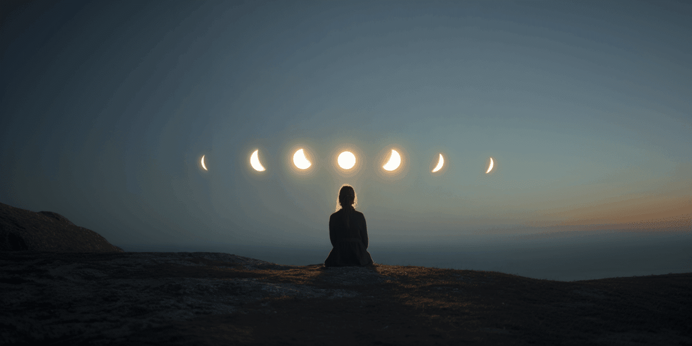 Woman observing moon phases at dusk.