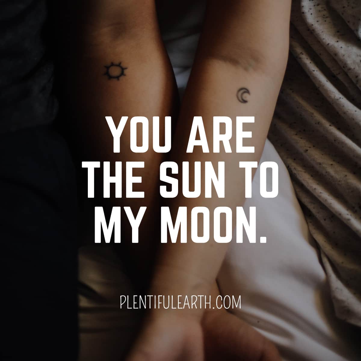 Two arms lying side by side, each tattooed with a celestial symbol—the sun on one, the moon on the other—symbolizing a cosmic connection with the words 'you are the sun to my