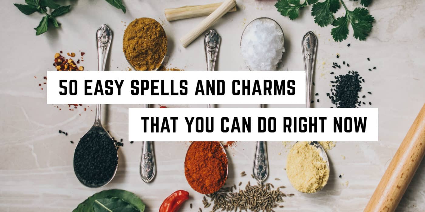 Assorted spices and herbs neatly arranged on a table with text overlay: "50 easy spells and charms that you can do right now for your spiritual journey.