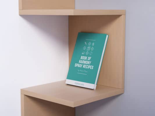 Free Witchcraft Items 2 A book titled "book of metaphysical harmony spray recipes" stands upright on a wooden shelf against a clean, light-colored background.