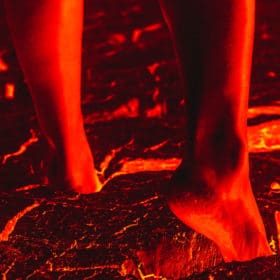 A person walking across lava barefoot