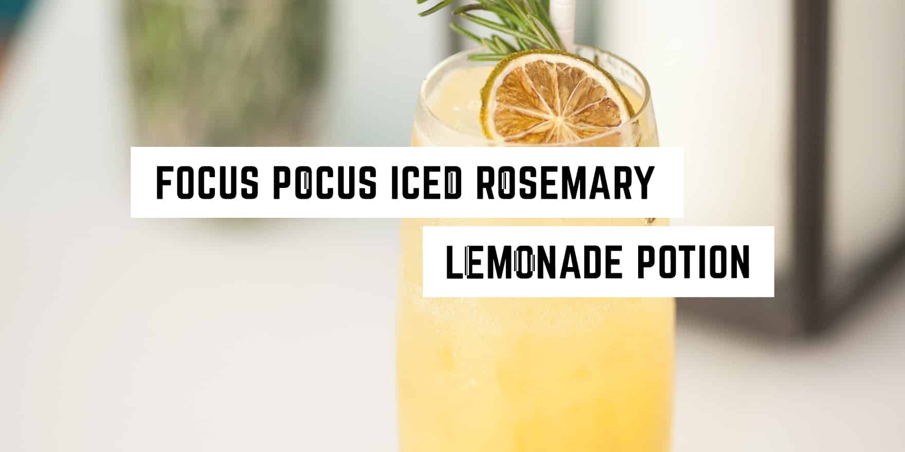 A refreshing glass of rosemary-infused lemonade garnished with a sprig of rosemary and a slice of lemon, playfully dubbed as a "focus pocus iced rosemary lemonade