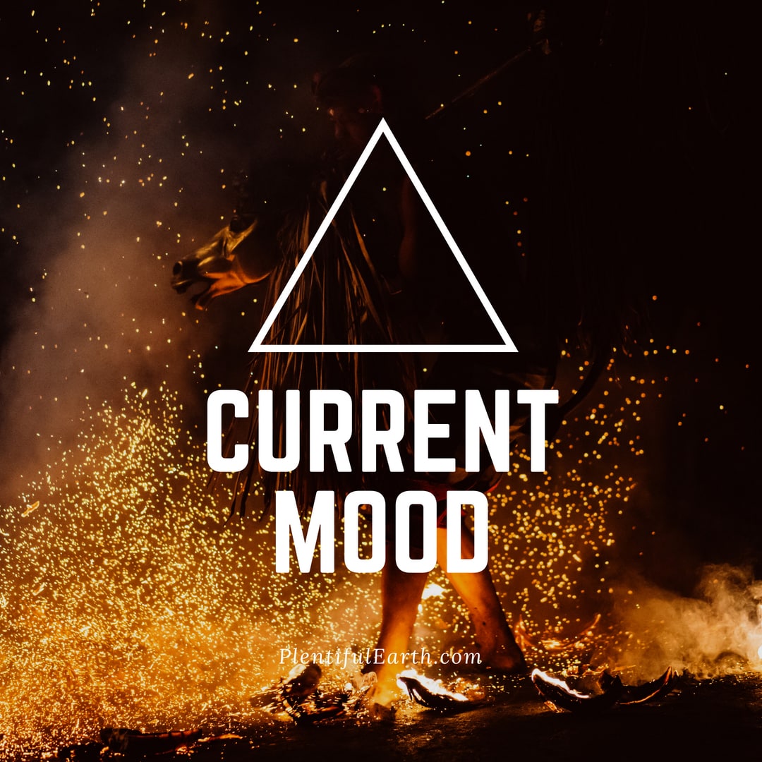 A silhouetted figure stands before a fiery backdrop with sparks flying around, overlaid with the bold text "current mood" inside a triangle, suggesting a feeling of intensity or turmoil in a metaph