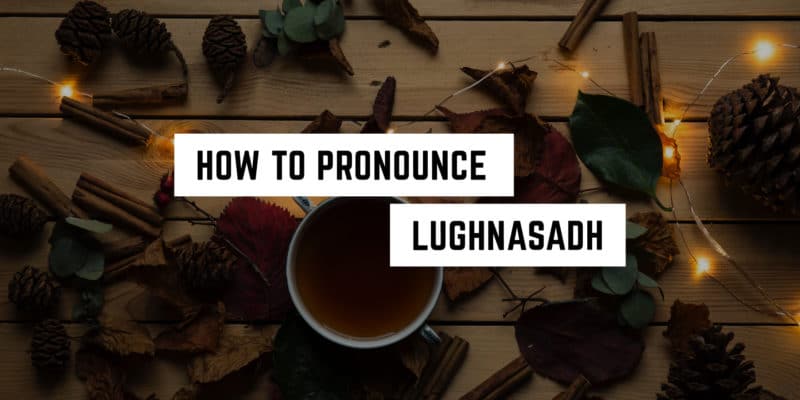 How to Pronounce Lughnasadh 6 Autumn ambiance with a witchy tutorial: "how to pronounce lughnasadh" surrounded by pine cones, autumn leaves, a cup of tea, and twinkling string lights on a wooden surface