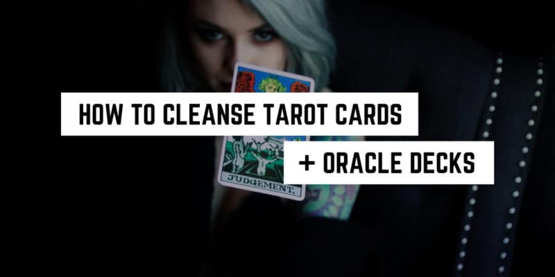 How to Cleanse Tarot Cards and Oracle Decks 4 A mysterious figure holding tarot cards with text overlay 'how to cleanse tarot cards + oracle decks in a witchy manner'.