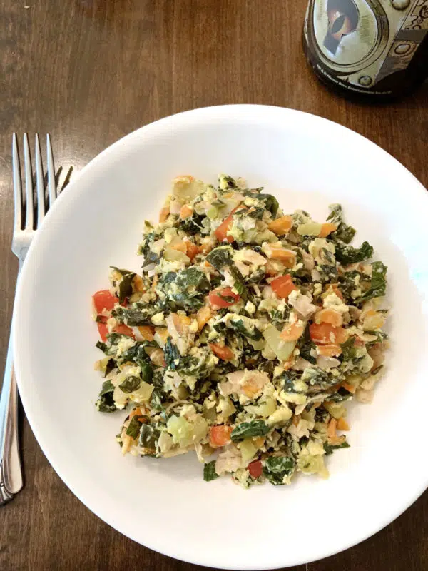 Midsummer: The Reawakening of a Witch 3 A white plate filled with a salad made of kale, carrots, and herbs.