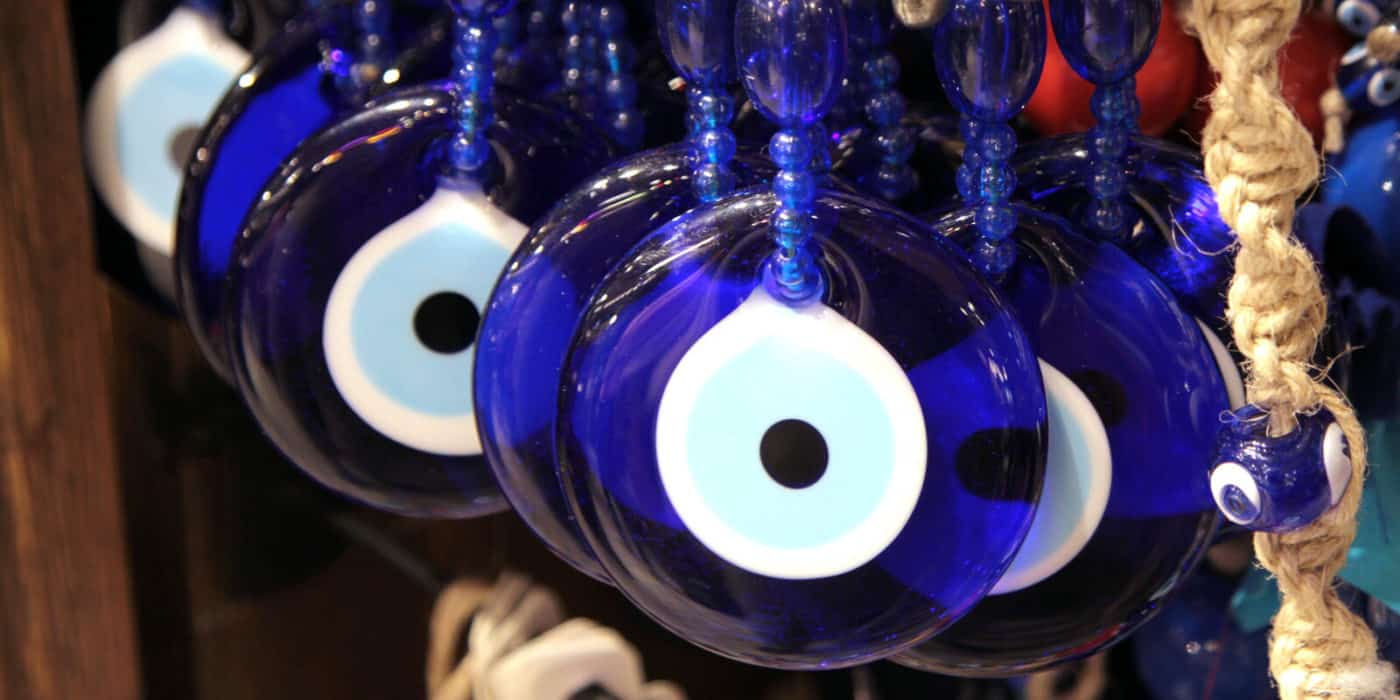 4 blue glass eye nazars hanging to protect against the evil eye