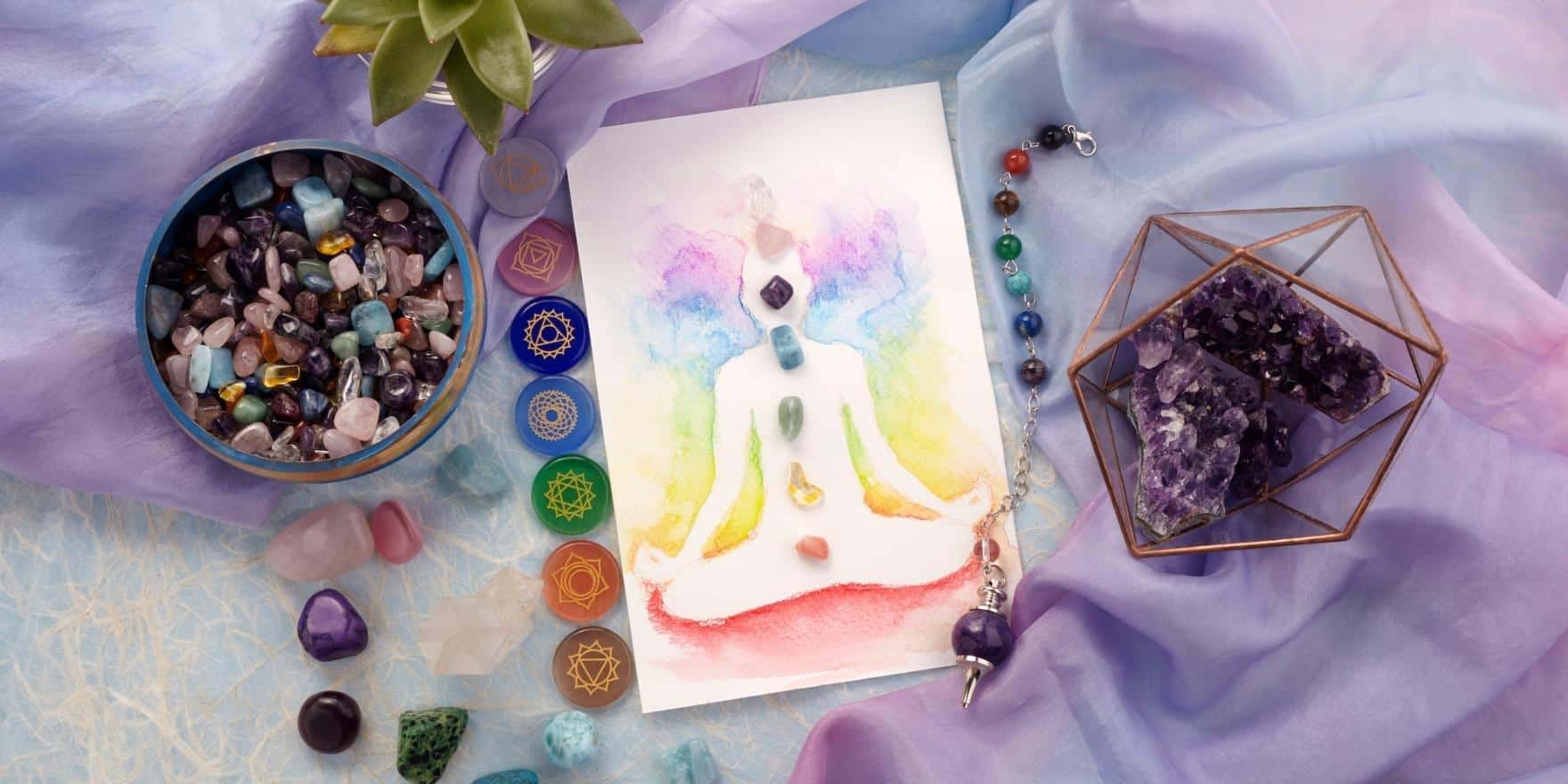 A chakra crystal guide with chakra crystals around it on a purple table