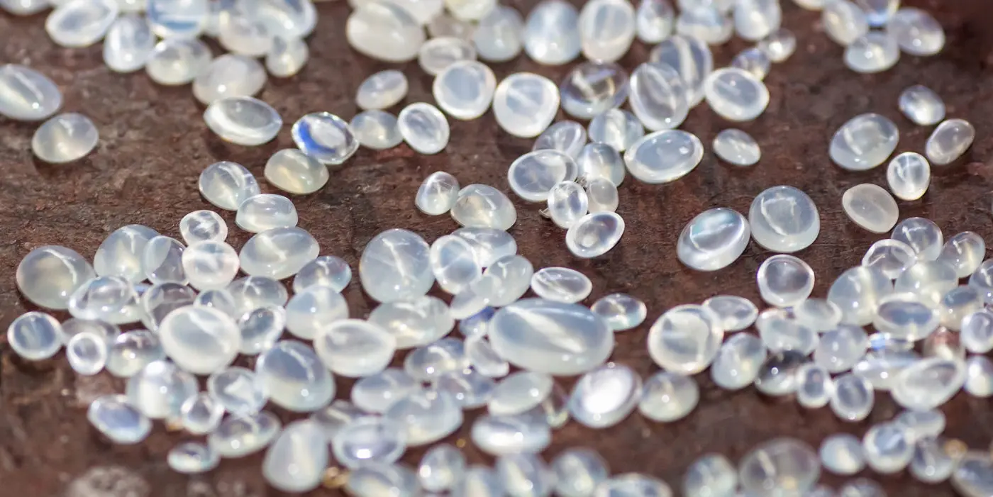 Scattered translucent beads glistening on a textured surface in a witchy metaphysical shop.