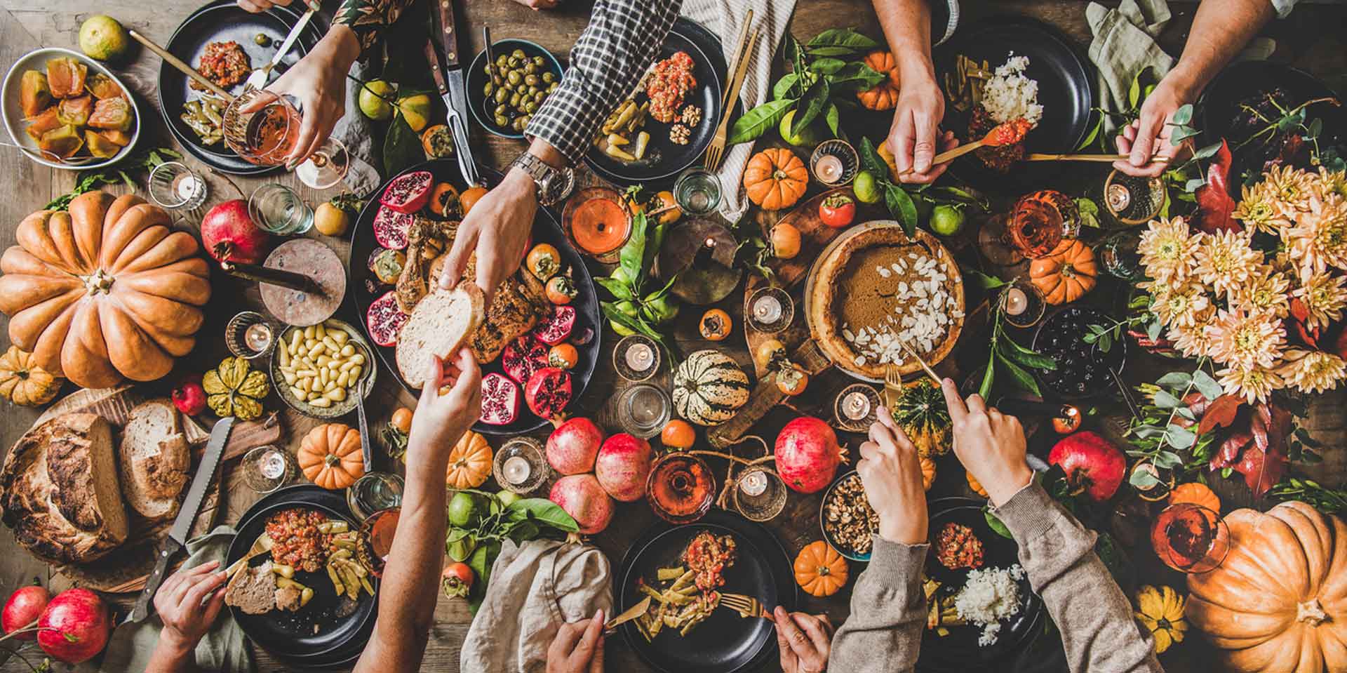 A festive autumnal feast with friends gathered around a table laden with seasonal produce, New Age products, and hearty dishes, sharing the warmth of good company.