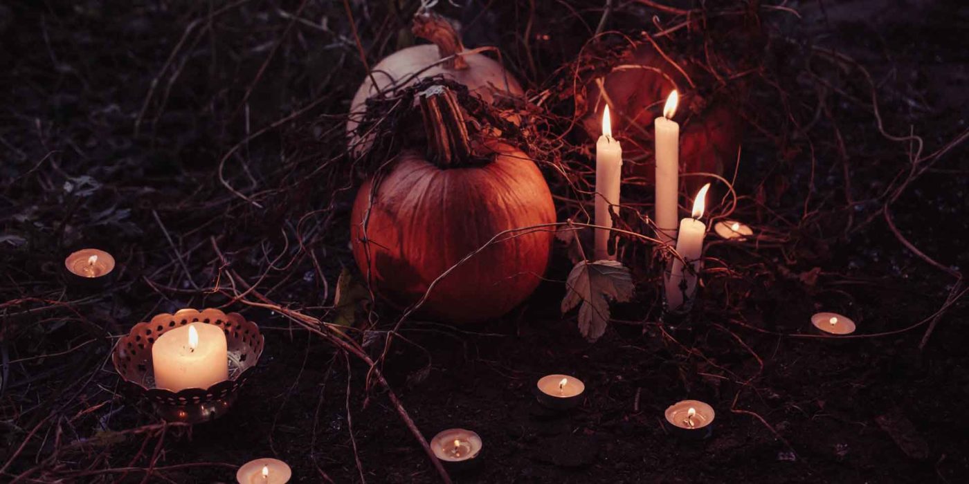 An atmospheric autumn scene with pumpkins and flickering candles entwined in bare branches, evoking a sense of mystery and the spirit of Halloween, perfect for creating a metaphysical ambiance.