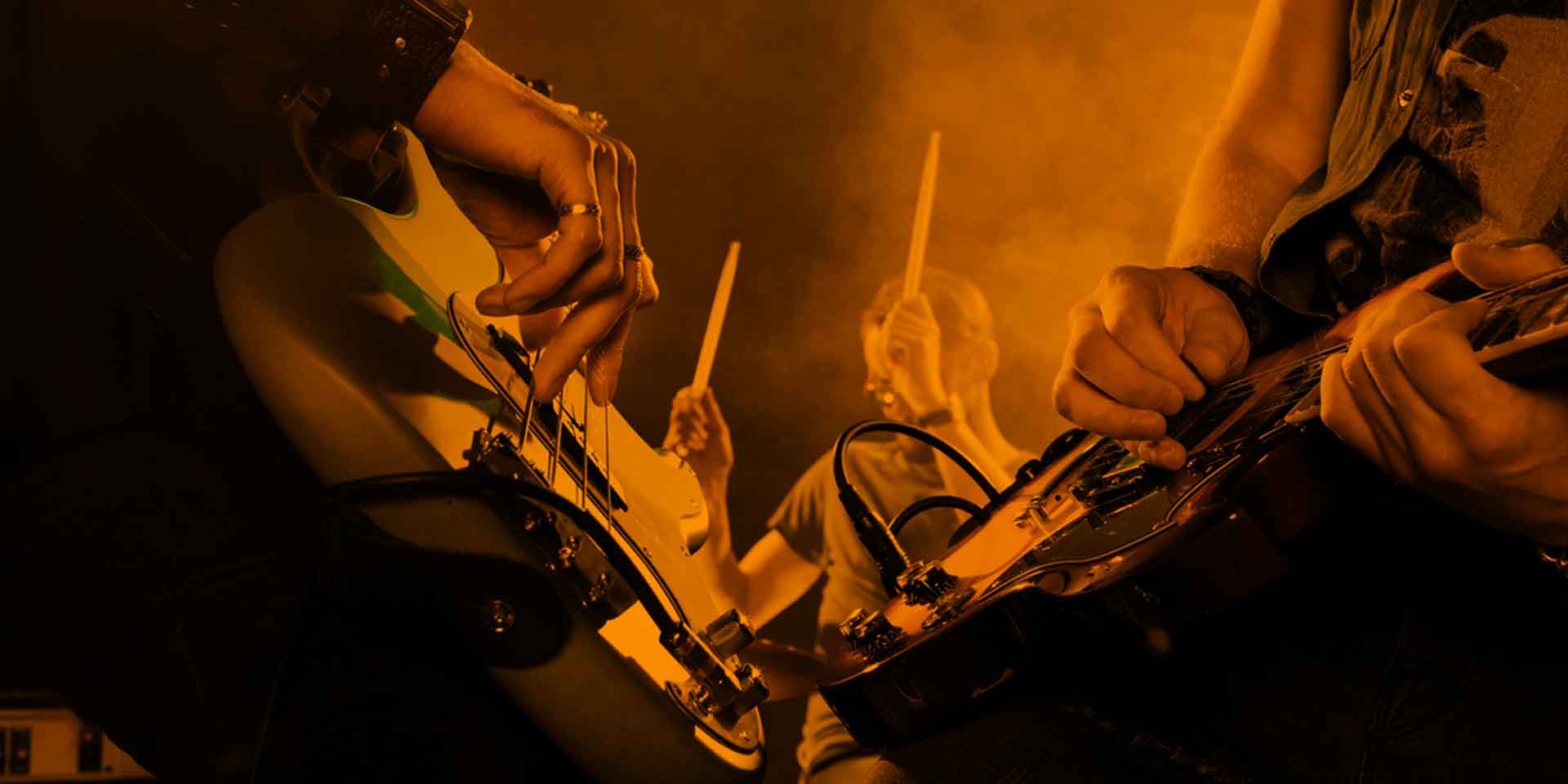 Band members lost in the groove during a smoky and intense live rock performance, their synergy verging on the metaphysical.