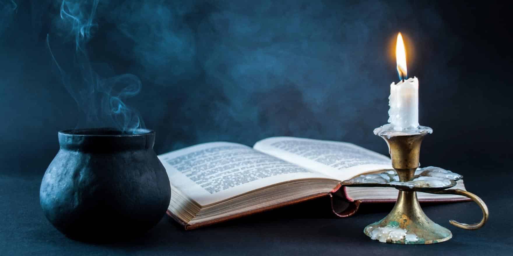A book, candle, and cauldron on a table