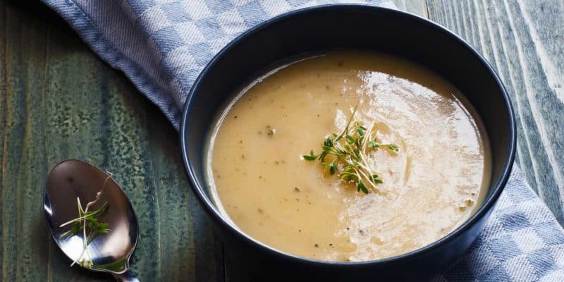 Simple Keto & Gluten-Free Cauliflower Cheddar Soup 33 Cauliflower cheddar soup in a dark bowl on a dark wooden table
