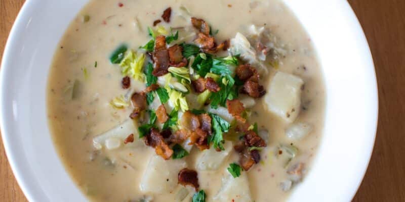 Creamiest New England Clam Chowder Recipe 31 A bowl of creamy white clam chowder with bacon on top