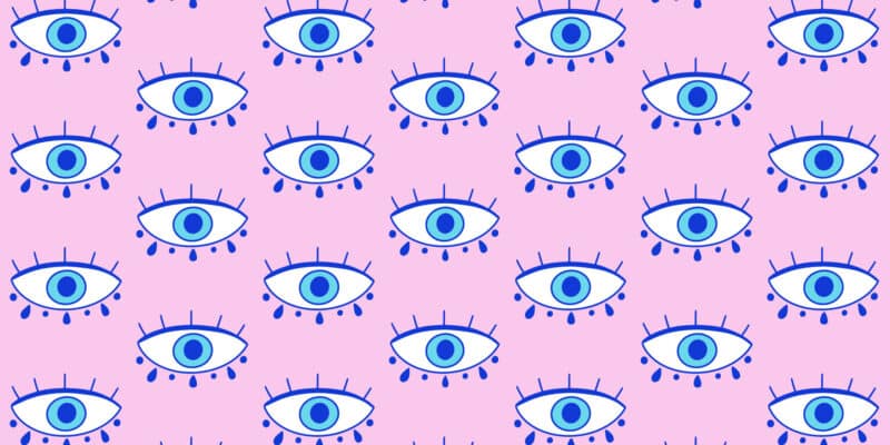 How We Use The Nazar Charm To Protect Us From The Powerful Evil Eye Curse 9 A pink background with repetitive blue evil eye illustrations in a pattern