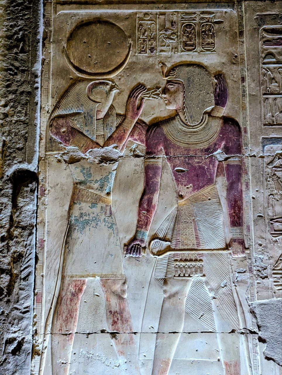 Ra holding an ankh Egyptian relief Plentiful Earth | Global Spirituality Painted Egyptian temple relief of the falcon-headed god Ra holding an ankh up to the face of the figure before him