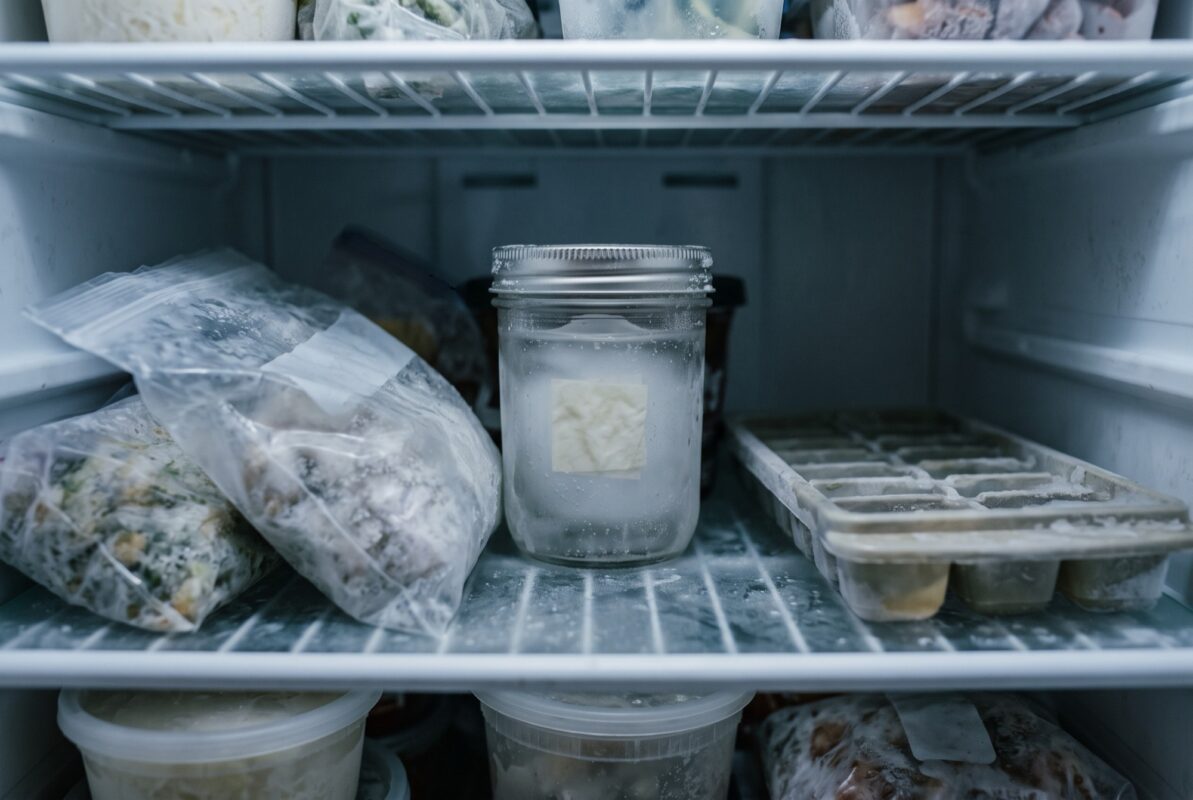 A frozen spell jar at the back of a home freezer shelf.