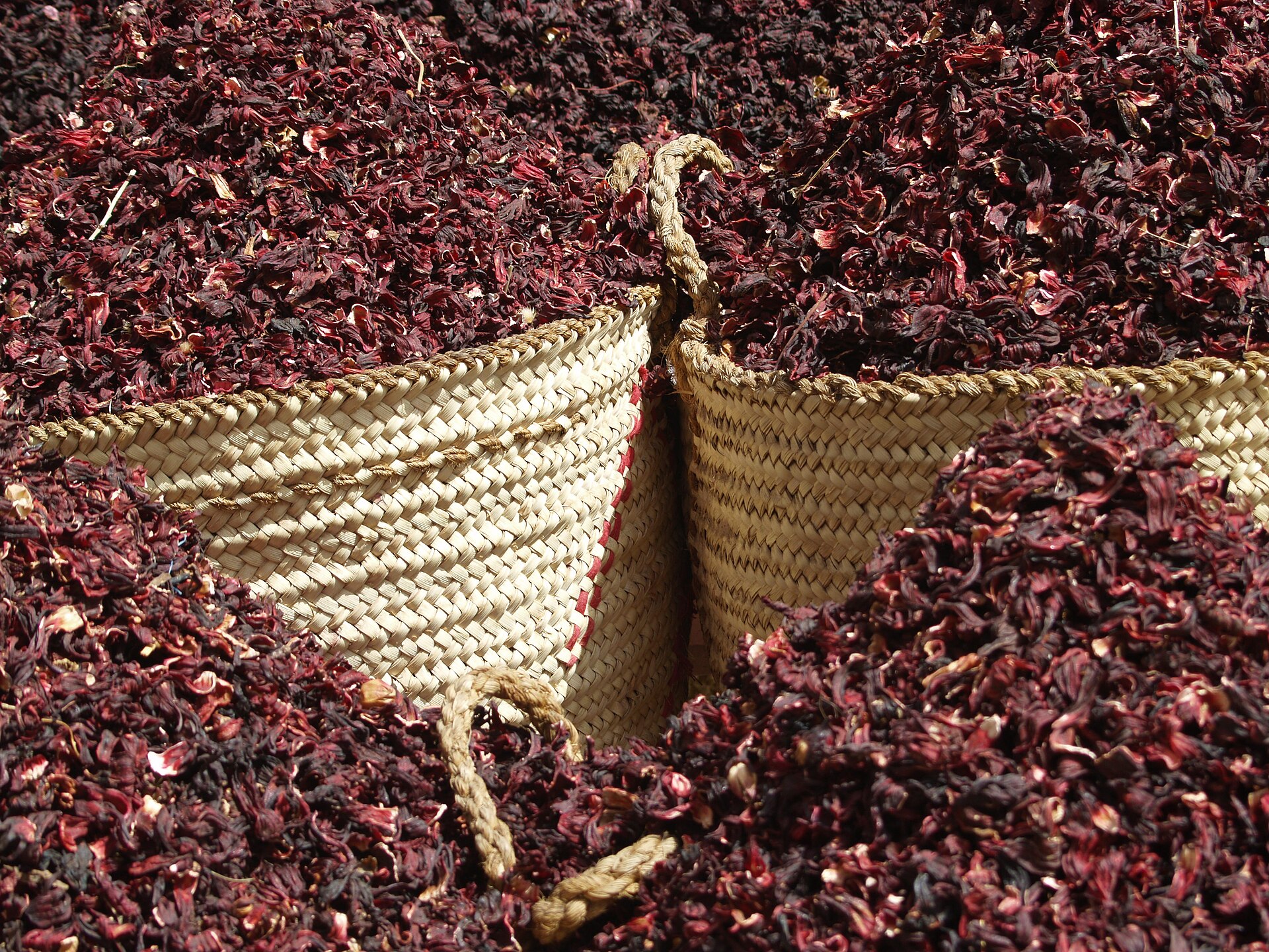 Baskets of dried red hibiscus calyces for karkadé at a market in Aswan, Egypt