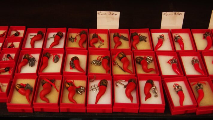 Italian horn charms in Naples Plentiful Earth | Global Spirituality Rows of red cornicelli, Italian good-luck horns, displayed in small red gift boxes in a shop in Naples.