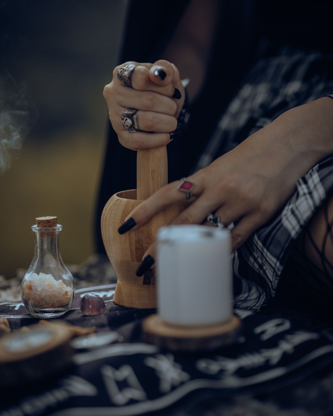 White candle and mortar for a protection spell Plentiful Earth | Global Spirituality Hands working a mortar and pestle beside a lit white candle on a dark altar cloth