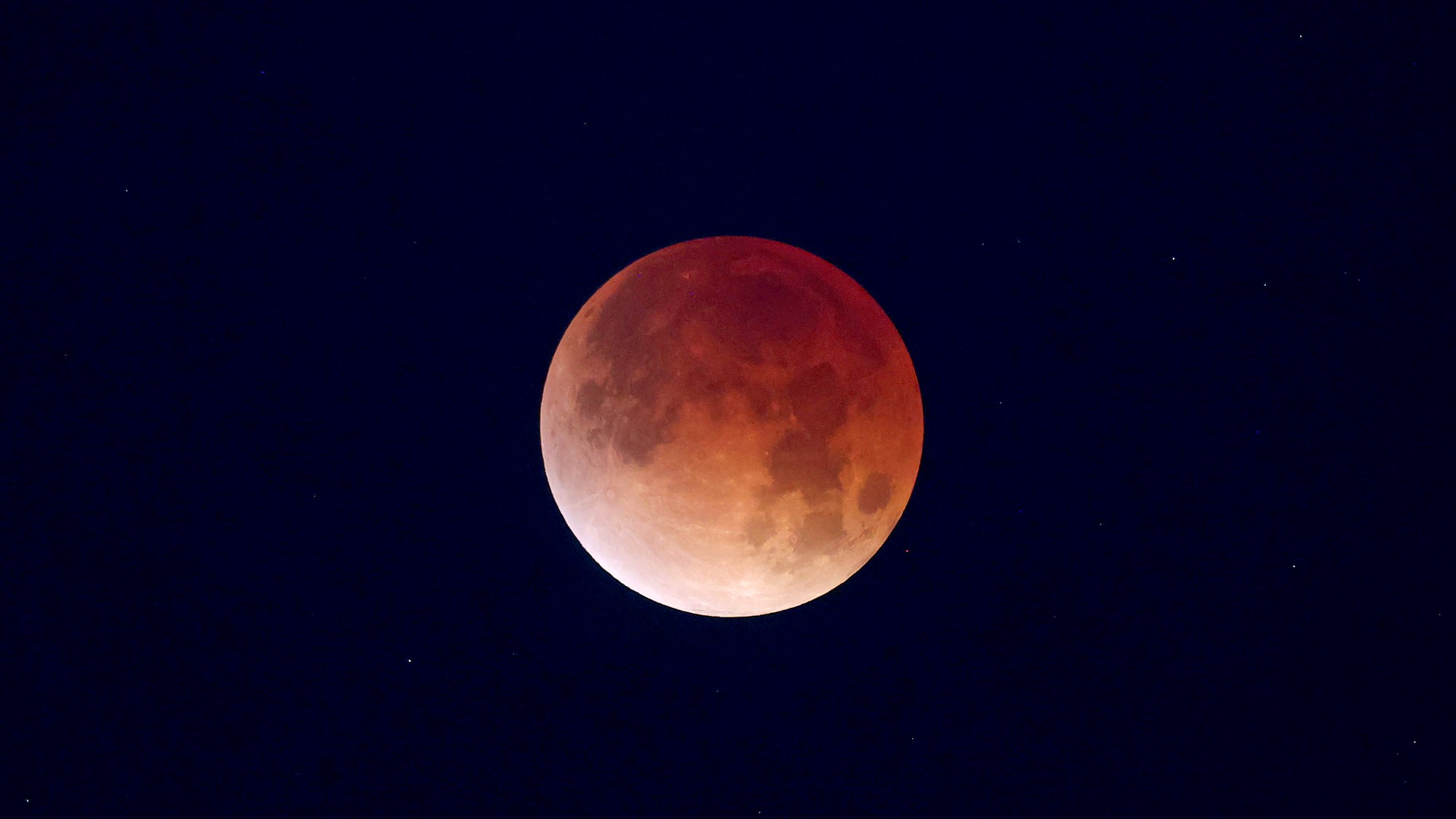 A copper-red full moon during the total lunar eclipse of March 3, 2026, against a deep blue night sky.