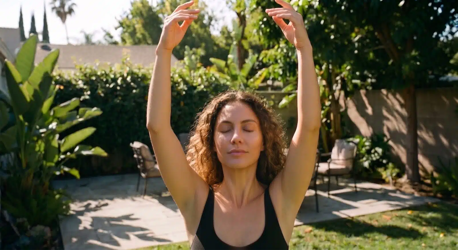 a woman holding her hands overhead to grab the suns energy and absorb it