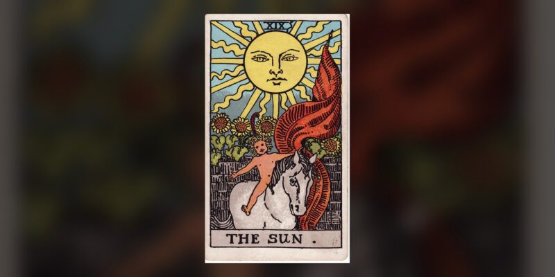 The Sun tarot card from the 1909 Rider-Waite-Smith deck, centered on a dark background