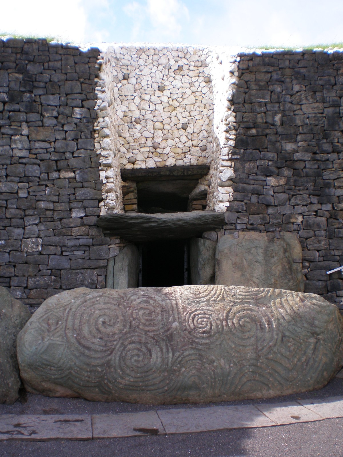 Newgrange entrance stone Plentiful Earth | Global Spirituality The large entrance stone at Newgrange covered in carved spirals, in front of the tomb entrance and its white quartz wall
