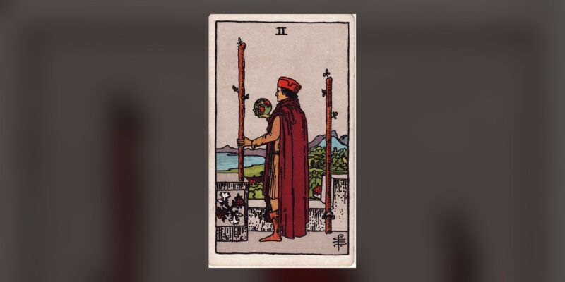 Two of Wands tarot card Plentiful Earth | Global Spirituality The Two of Wands tarot card from the 1909 Rider-Waite-Smith deck, centered on a dark background
